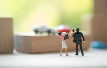 Fototapeta na wymiar Miniature people adult couple and baby figure standing and looking to further