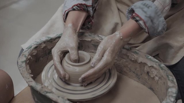 Close-up on creativity. Top view of potter making ceramic on the pottery wheel