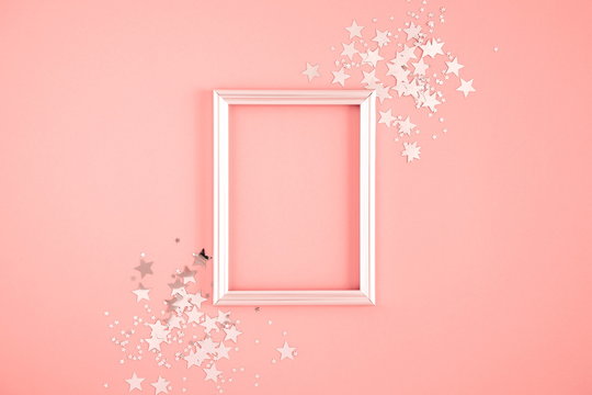 Festive elegant background. Blank photo frame on pastel pink background. Christmas, New Year, birthday concept. Flat lay, top view, copy space 