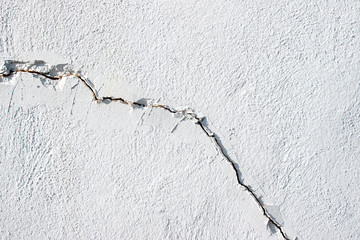 White wall with diagonal crack fracture texture close up detail surface