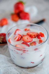 Strawberries and milk in a glass Cup. the concept of a light summer dessert.