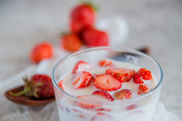 Strawberries and milk in a glass Cup. the concept of a light summer dessert.