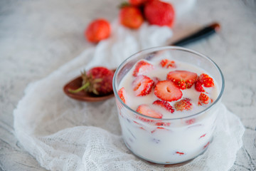 Strawberries and milk in a glass Cup. the concept of a light summer dessert.