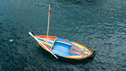 Drone aerial view of an old colorful wooden fishing boat.