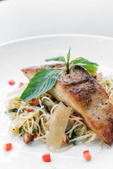 fresh fish fillet on mixed vegetable and parmesan spaghetti pasta