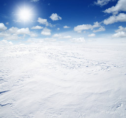 Fototapeta na wymiar Snowcovered fields on sky and sun.