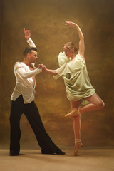Flexible young modern couple dancing tango in studio. Fashion portrait of attractive dancing...