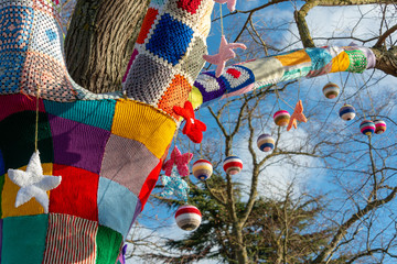 branch of tree with Christmas knitted yarn bomb