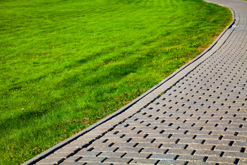 Stone path in the park and green lawn.