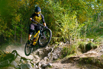 Professional Cyclist Riding the Mountain Bike on Autumn Forest Trail. Extreme Sport and Enduro...