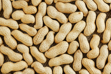 Peanuts in their shell textured food background.