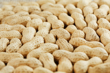 Peanuts in their shell textured food background.