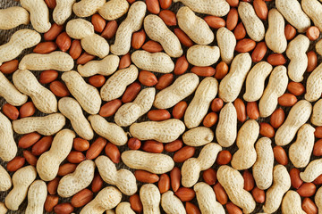 Peanuts in a shell mixed with peeled, the texture of the food background of beans