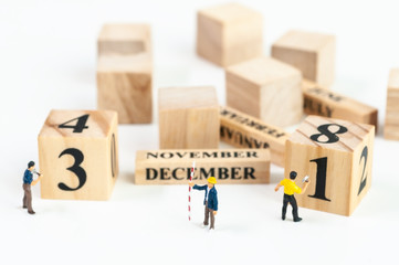 Selective focus miniature civil engineer and worker working set up with calendar wooden blocks 31 December end of year, celebration concept.
