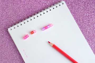 New year 2019 to do list with colorful plastic letters in spiral paper album. color red pencil and notebook on shiny sparkle glittery pink background. back to school.