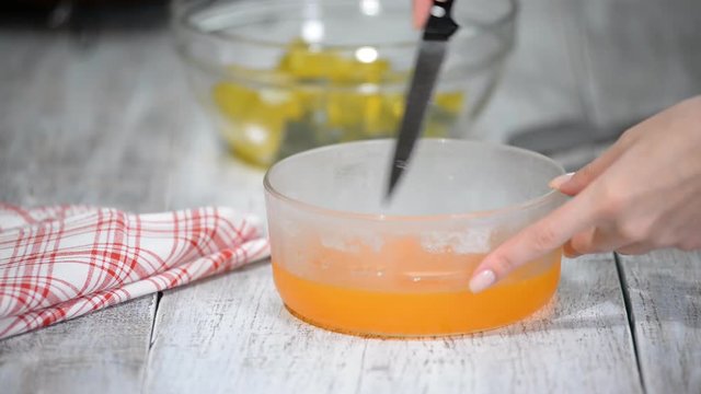 Cutting orange jelly into pieces.