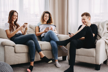 leisure, social media, technology, fun concept. company of young people having fun using gadgets, students spend time together busy with smartphones, millennial friends addicted to cell phones