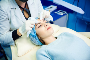 Naklejka na ściany i meble face cleaning process. The doctor conducts the procedure of cleaning the face. The concept of treatment and skin care.