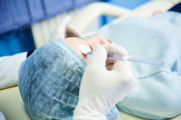 face cleaning process with a cosmetic brush. The doctor leads the brush on the face of a beautiful girl. The concept of treatment and skin care.