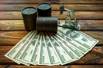 barrels of oil. neftekachka, bills American dollars on wooden background.  fuel industry. production and sale of oil.