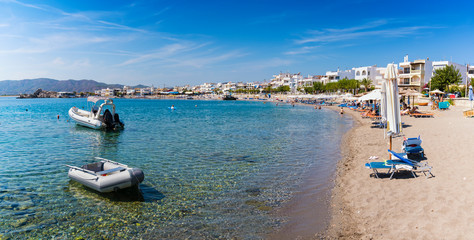 Fototapeta na wymiar Boats and umbrellas in Haraki beach – sunny day (Rhodes, Greece)