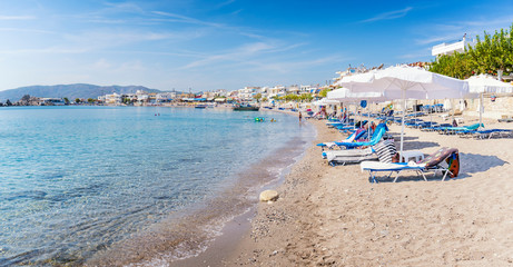Fototapeta na wymiar Sun beds and sun shades in Haraki beach – (Rhodes, Greece)