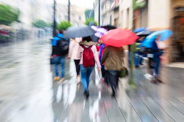 people walking in the rainy city with zoom effect
