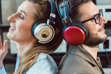 Paar mit Kopfhörer hört Musik von der Stereoanlage 