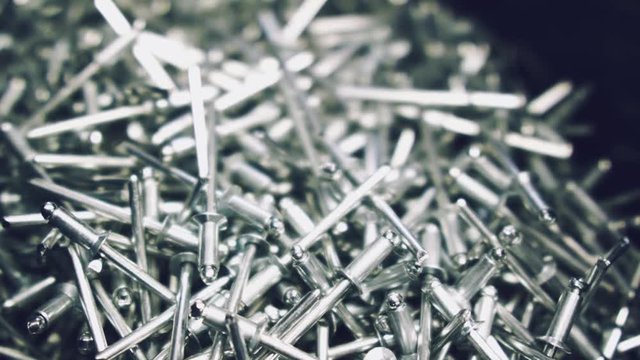 Closeup of metallic new rivets in a container. Macro shooting of metal rivets with changing sharpness zone.