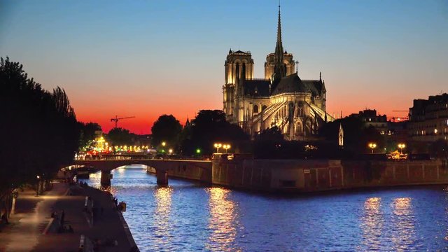 Cathedral of Notre Dame and riverside of Seine river in Paris at twilight sunset, France, background loop