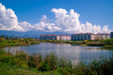 Fototapeta na wymiar city blocks near the lake on a background of mountains