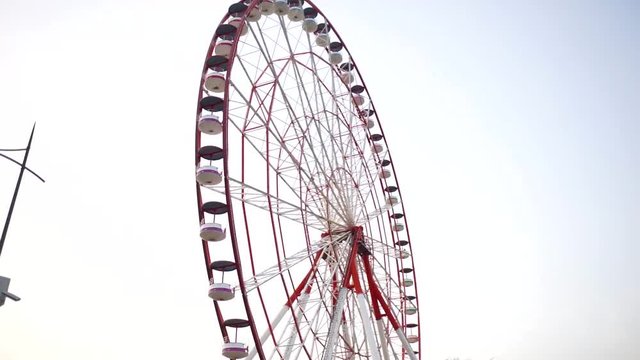 Lighthouse shines on the beach. Lighthouse next to the Ferris wheel. Ferris wheel in the amusement Park. Rest in the amusement Park. Lighthouse at sunset tonight.