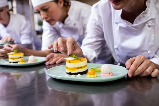 Chef Garnishing Dessert On Plate