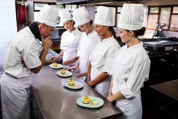 Head chef inspecting dessert plates