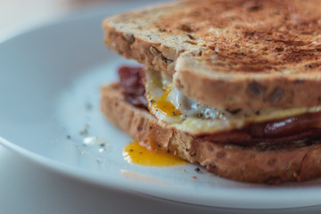 Fototapeta na wymiar Homemade Breakfast Egg Sandwich with Cheese and bacon on Toast