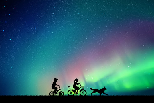 Children On Bicycles And Running Dog In Park At Night. Vector Illustration With Silhouettes Of Boy And Girl On Bikes. Northern Lights In Starry Sky. Colorful Aurora Borealis