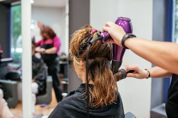 Fototapeta premium Hairdresser drying woman's hair