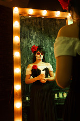 Picture of zombie girl with white face and red flower on her head