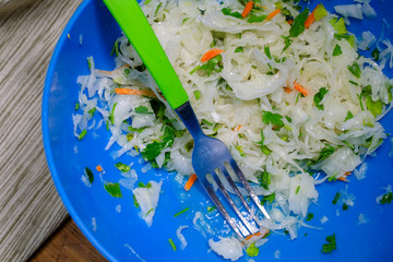 Obraz premium Homemade steamed sauerkraut with carrot and herbs - traditional dish of Ukrainian, Russian and Asian cuisine. Contains many vitamins A, B and C.
