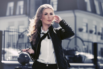 Fototapeta premium Young fashion blond business woman walking in city street