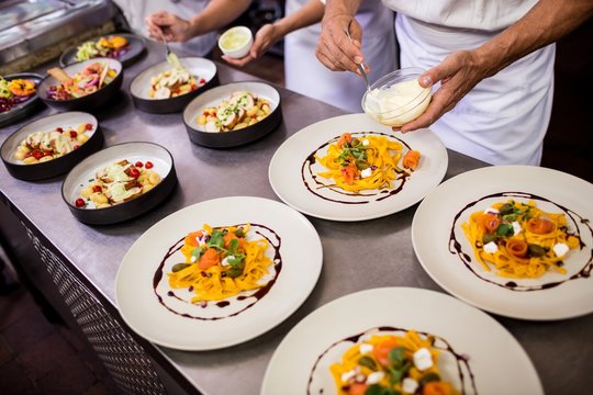 Chef garnishing food on plates
