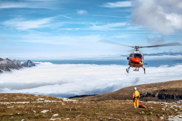 roter Helikopter mit Person in den Bergen  © Martina