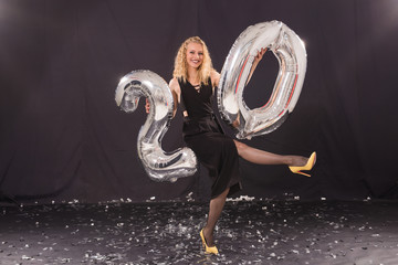 Happy birthday concept - Beautiful young woman with number-shaped 20 balloons