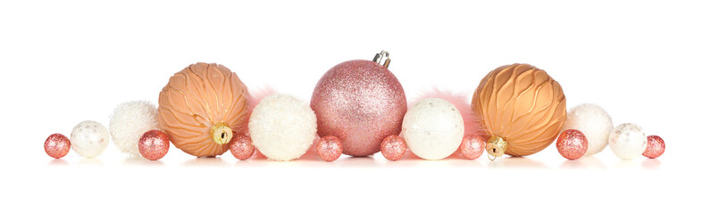 Christmas border of pink, rose gold and white decorations isolated on a white background