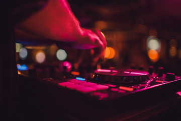 DJ remote, turntables, and hands . Night life at the club, party.