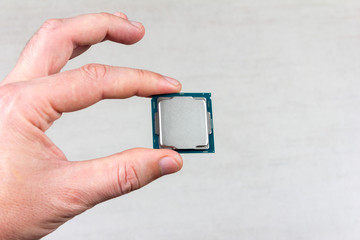 man holding fingers mock up desktop processor 8th gen on grey background closeup top view