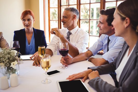 Business people interacting with each other on table