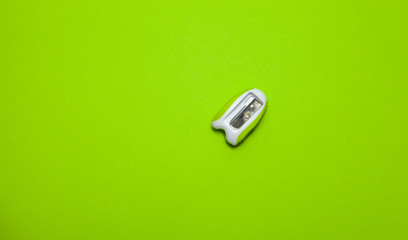 Pencil sharpener on a green background, top view