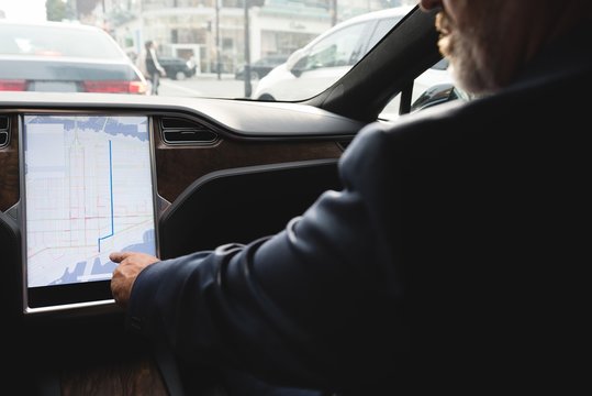 Businessman using navigator map while driving a car