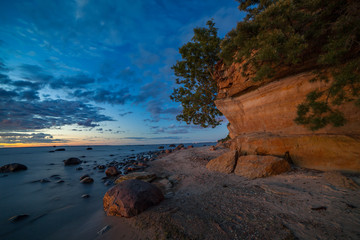 Fototapeta na wymiar Late sunset over the limestone cliff along the sea. Estonia.